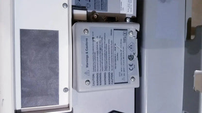 White rectangular electronic component with printed warnings on the back of bipap vision ventilatory support system 582059 with stand