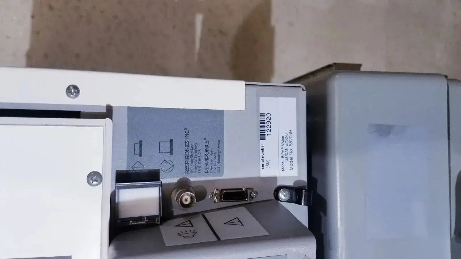 White industrial printer displaying model and serial number label of bipap vision ventilatory support system 582059 with stand
