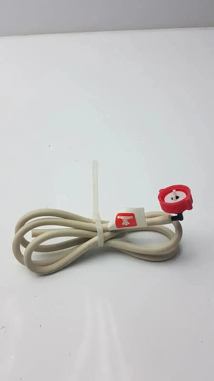 Beige coiled bosch water filter head hose with red nozzle attachment and white plastic tie for water filter use