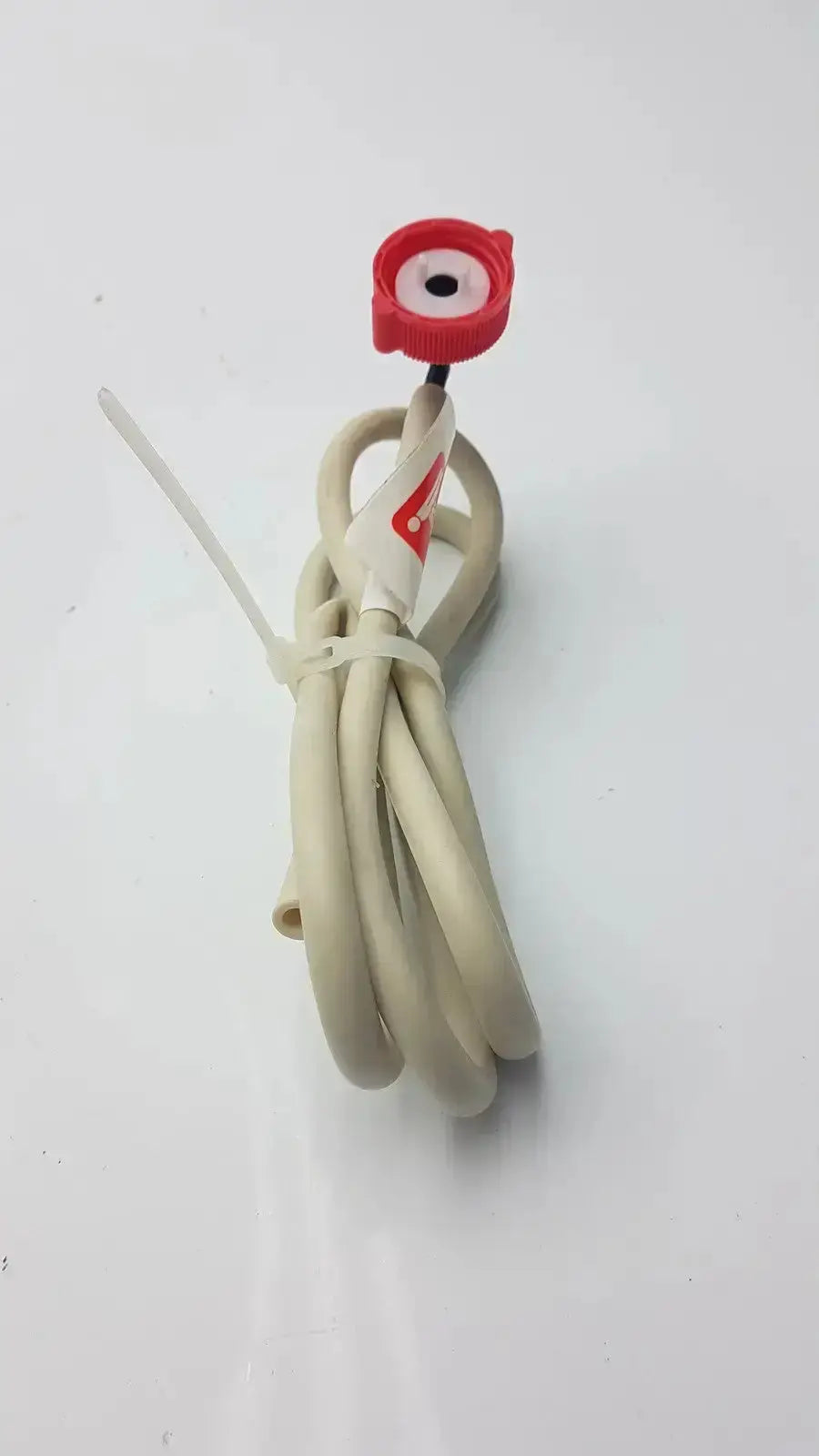 Beige coiled Bosch water filter head hose with red circular cap and white label for water filter installation