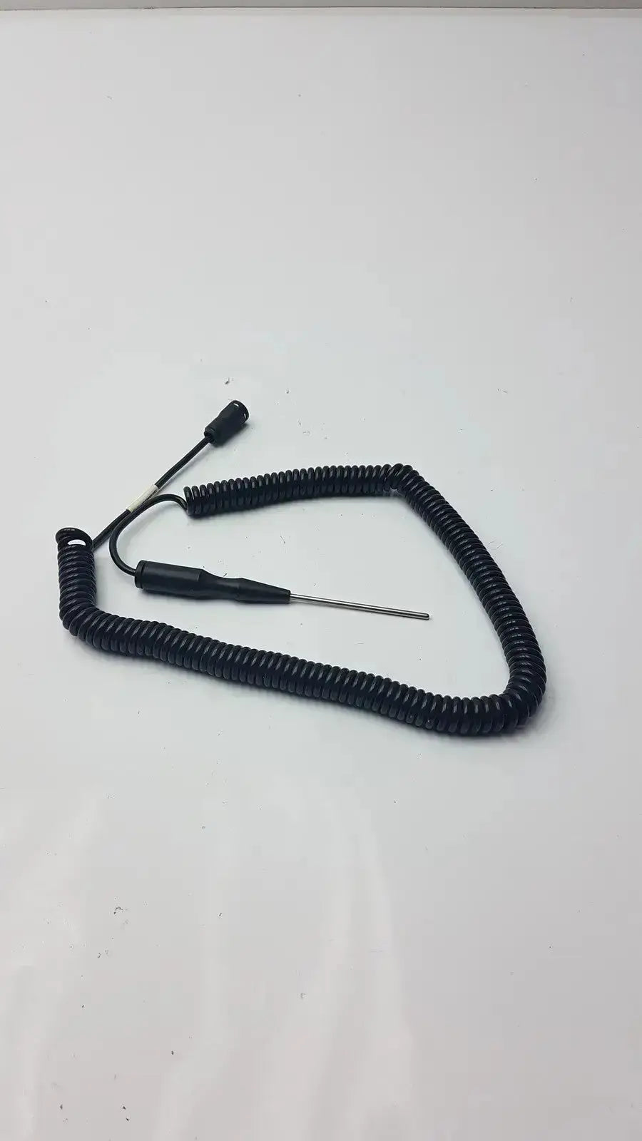 Black coiled cable thermometer probe with thin metallic tip and two connectors for hospital surplus biomedical technicians