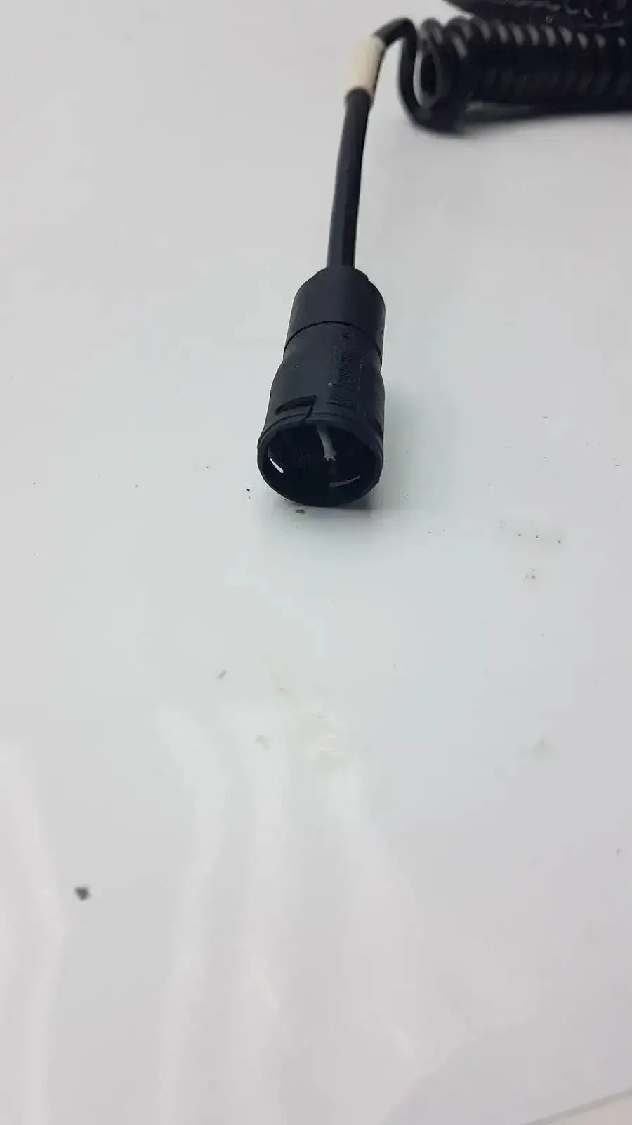 Black coiled cable with cylindrical connector for br thermometer probe used by biomedical technicians in hospital surplus