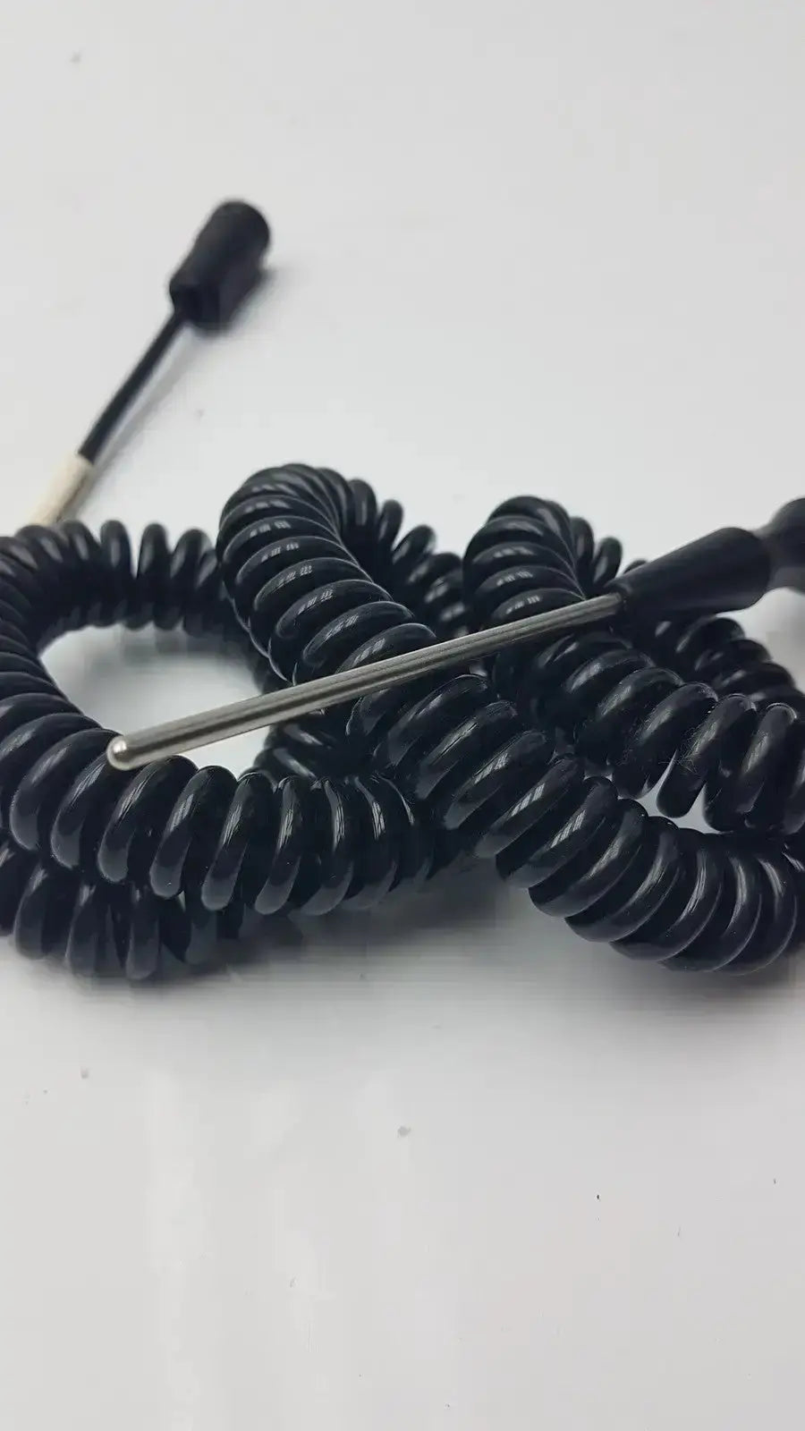 Black coiled thermometer probe cable with metallic tip and connector designed for hospital surplus use by biomedical technicians