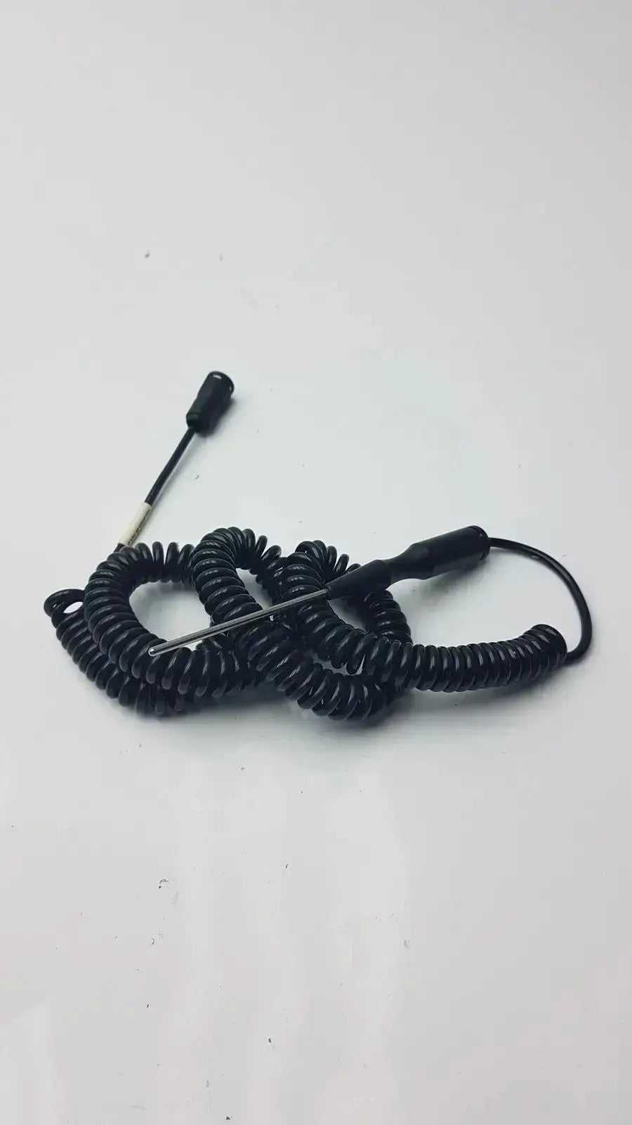 Black coiled thermometer probe with thin metal tip and two black plastic handles for biomedical technicians hospital surplus use