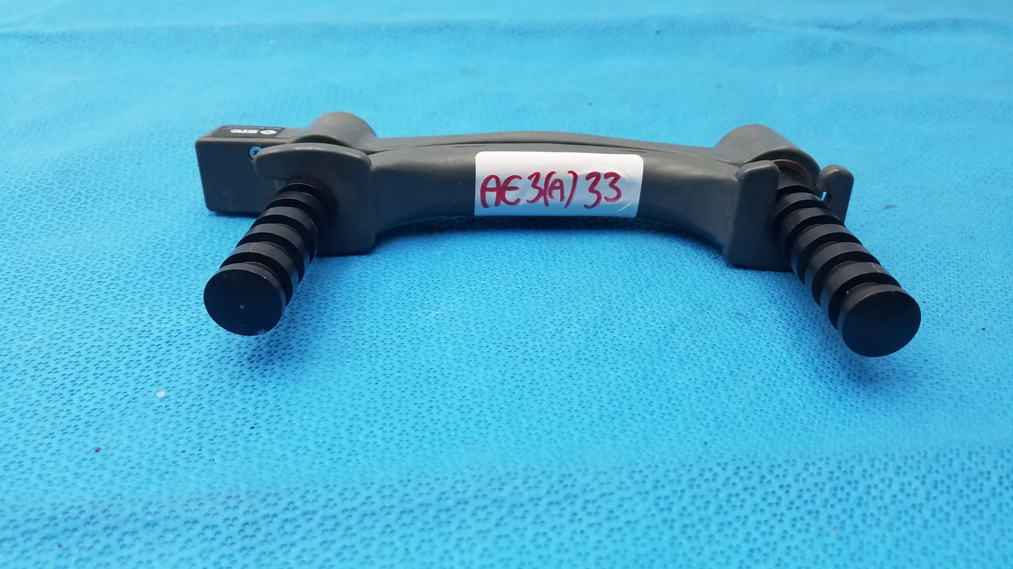 Black plastic hydraulic hand dynamometer tripod mount with textured grip handles and red handwritten label