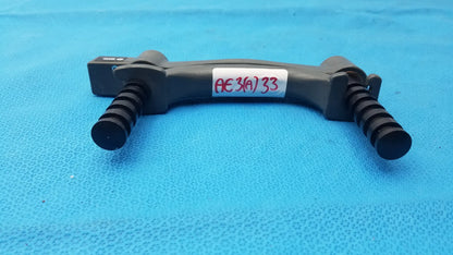 Black plastic hydraulic hand dynamometer tripod mount with textured grip handles and red handwritten label