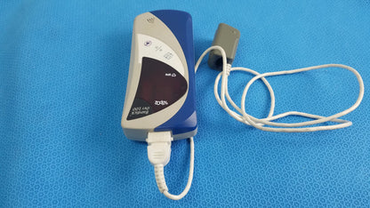 Blue and gray bionik ort-100 medical equipment with usb cable connected showing back side of burdick oxy 100 pulse oximeter ref 92521