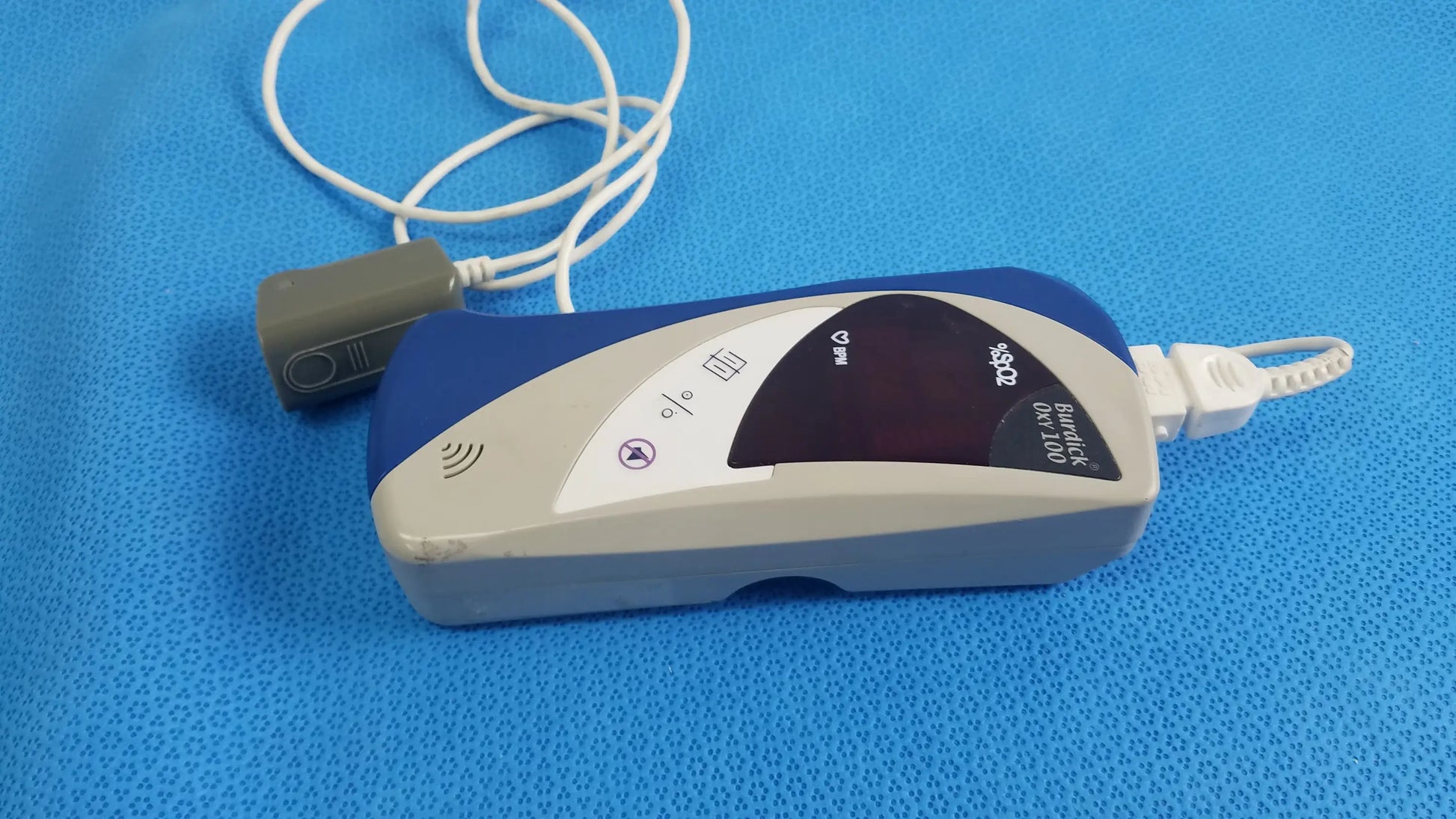 Burdick OXY 100 pulse oximeter ref 92521 medical equipment blue and gray handheld device with white cable for reuse medical equipment