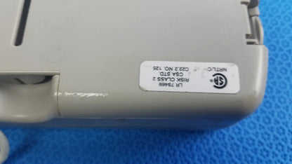 Gray plastic burdick oxy 100 pulse oximeter ref 92521 back with white label showing certification on medical equipment