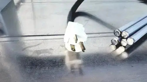 White plastic electrical plug with three prongs on reflective metallic surface for burlodge multigen ii blm52 returned items