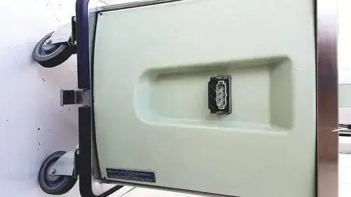 Cream-colored burlodge multigen ii blm52 medical cart with black wheels and electrical outlet compartment shown from backside