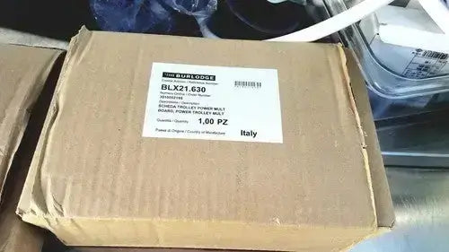 Brown cardboard box labeled as returned items containing schneider electric power multi model blx21.630 for burlodge multigen ii blm52