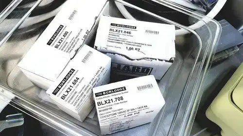 White rectangular boxes labeled burlington containing blx21 series electronic components for burlodge multigen ii blm52 returned items
