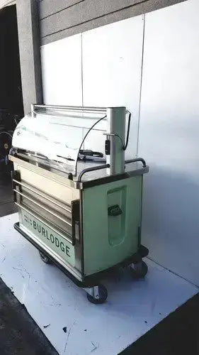 Light green metal food cart with glass display and black wheels branded the bur lodge for burlodge multigen ii blm52 returned items