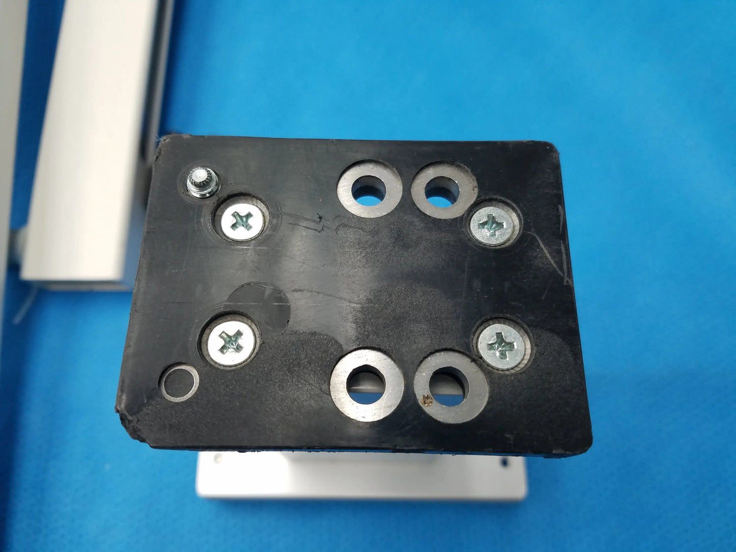 Black rectangular mounting plate with six silver screws and four washers for burton medical outpatient ii examination light wall mount assembly