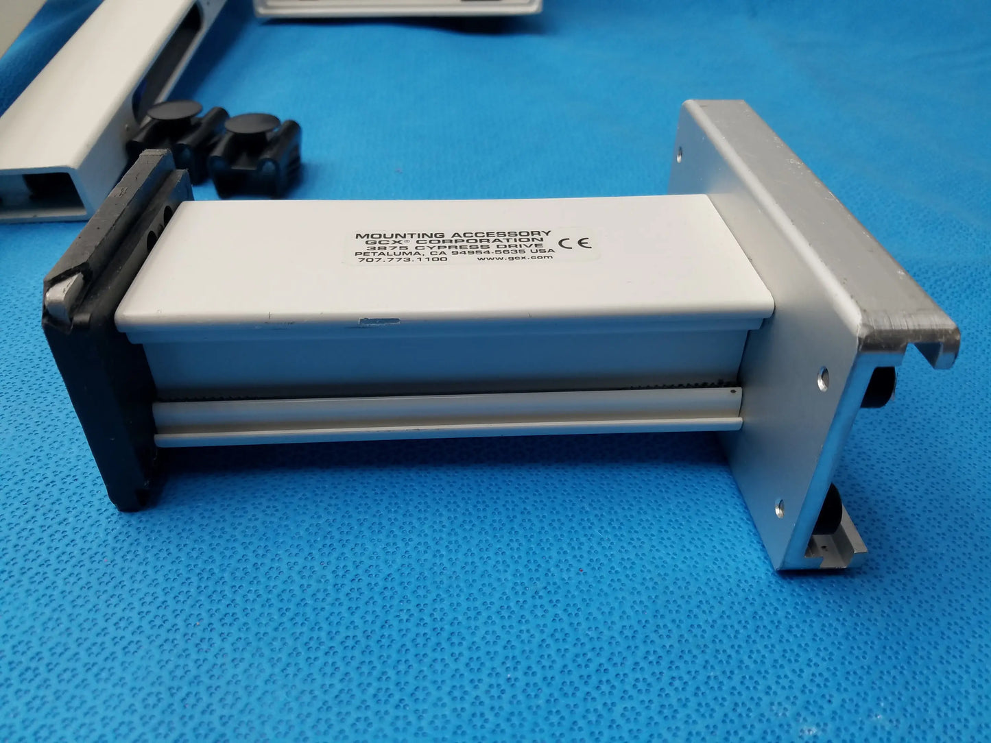 Silver and black metal wall mount accessory with white label for smiths medical equipment reuse medical equipment installation