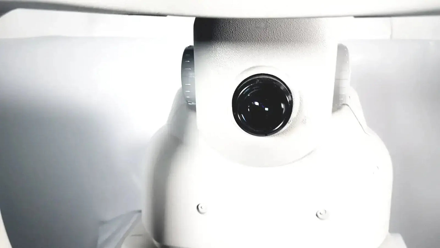 White robotic camera with black lens and metallic dial on zeiss stratus oct model 3000 patient module for imaging