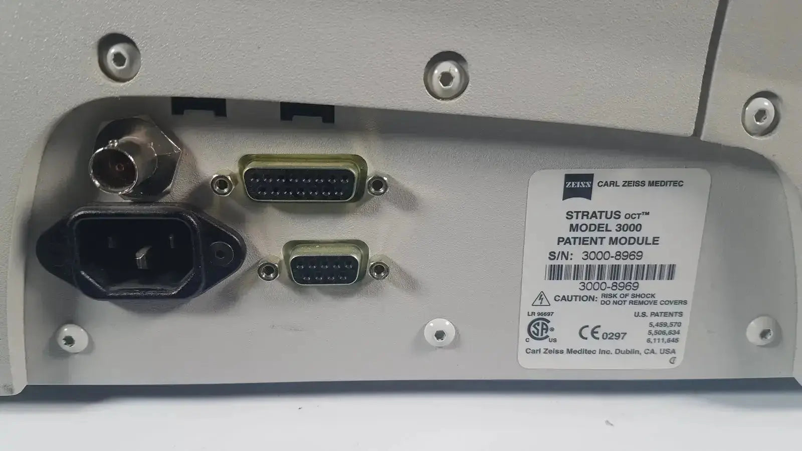 Silver-gray metallic back panel of carl zeiss stratus oct model 3000 patient module with multiple ports and label
