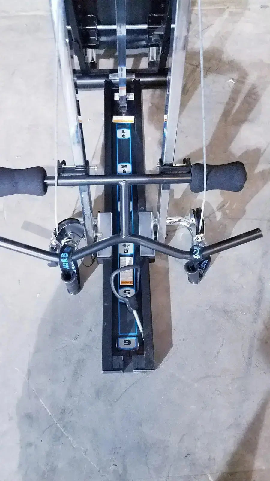 Black and silver total gym xls rowing machine with padded handles digital display and foot stand for full body workout