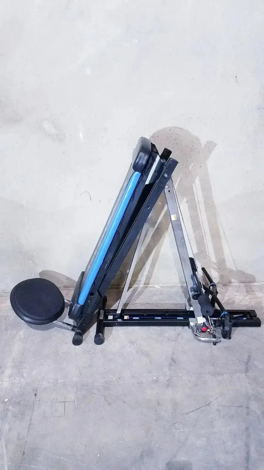 Black and blue adjustable total gym xls weight bench with padded seat, backrest, foot stand, and wing bar