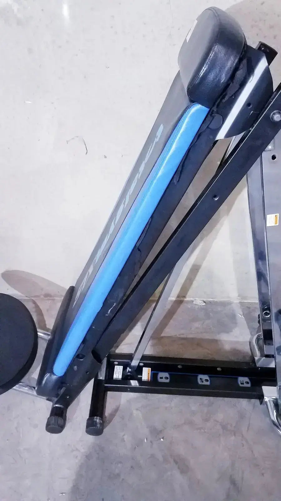 Black and blue adjustable total gym xls weight bench with padded seat and backrest featuring foot stand and wing bar