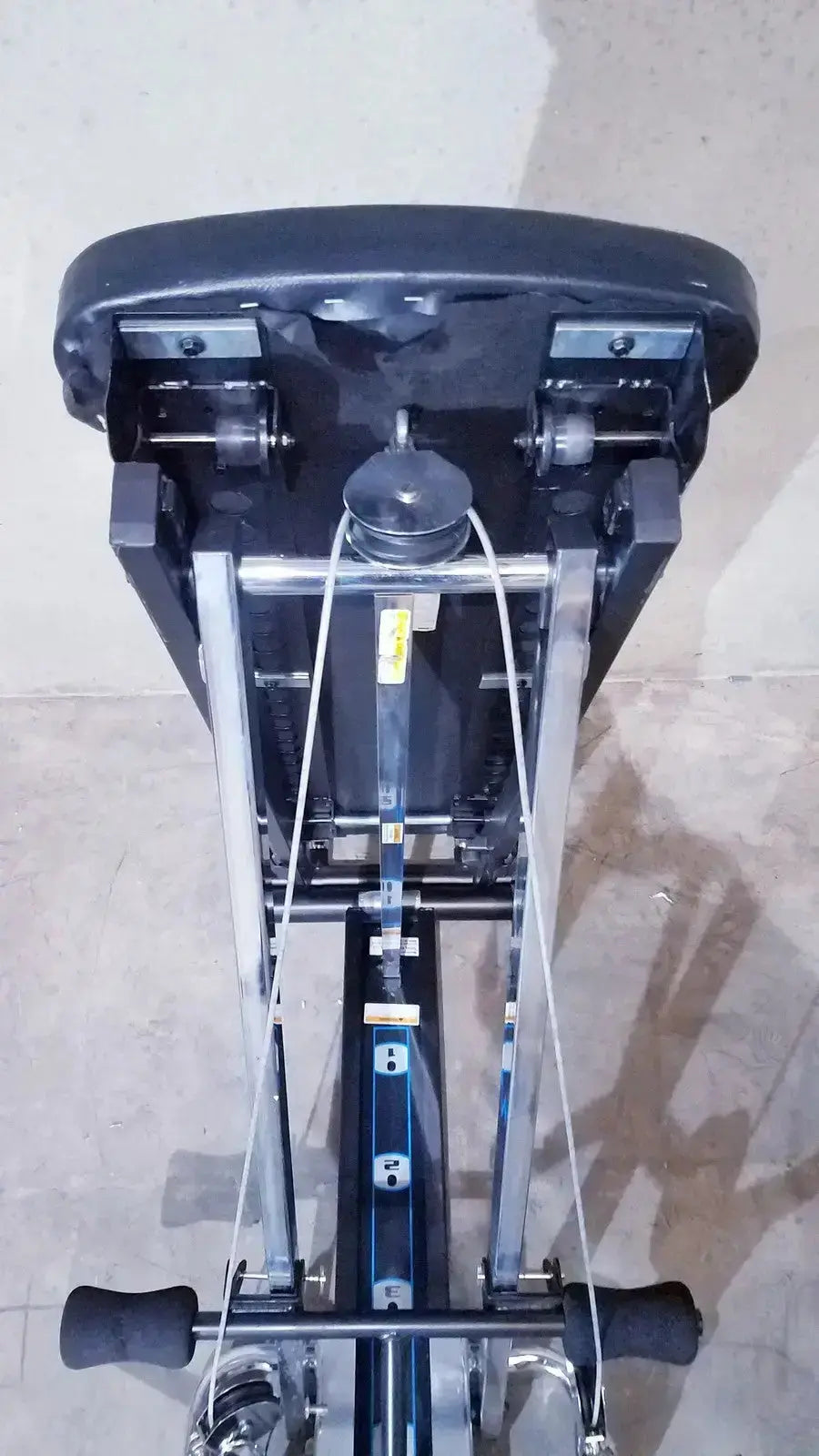 Black padded seat with metal frame and adjustable resistance cables on chuck norris total gym xls with foot stand wing bar