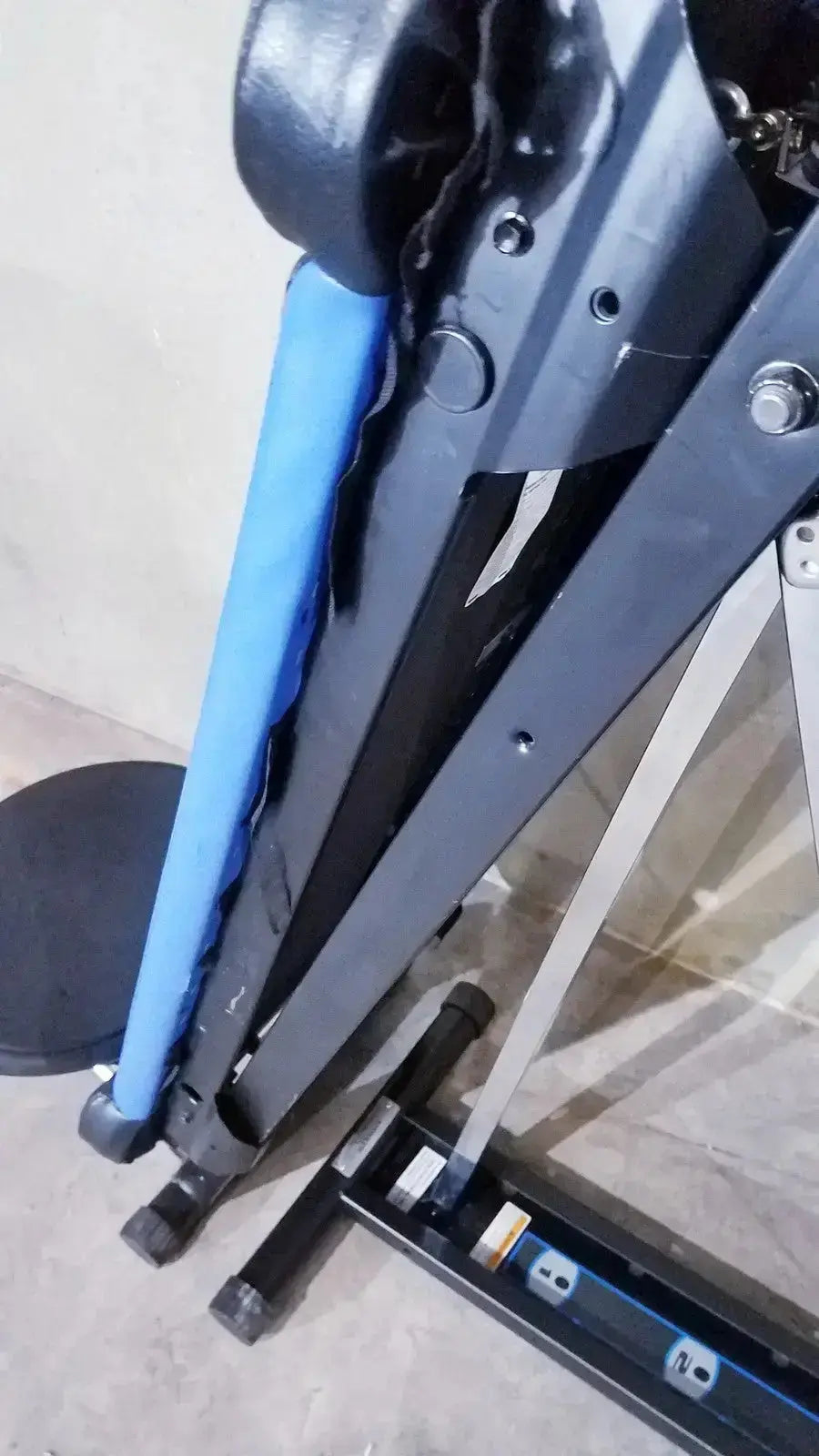 Black metal total gym xls exercise machine with blue padded handlebar featuring foot stand and wing bar attachments