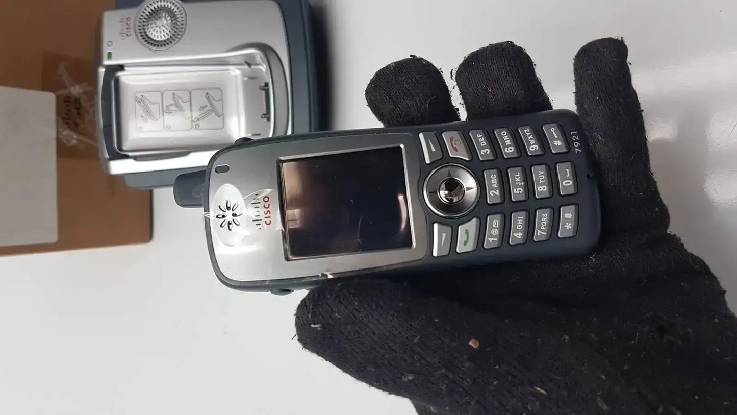 Black and silver cisco cp-7921g-a-k9 wireless ip phone with numeric keypad, circular navigation button, and small screen