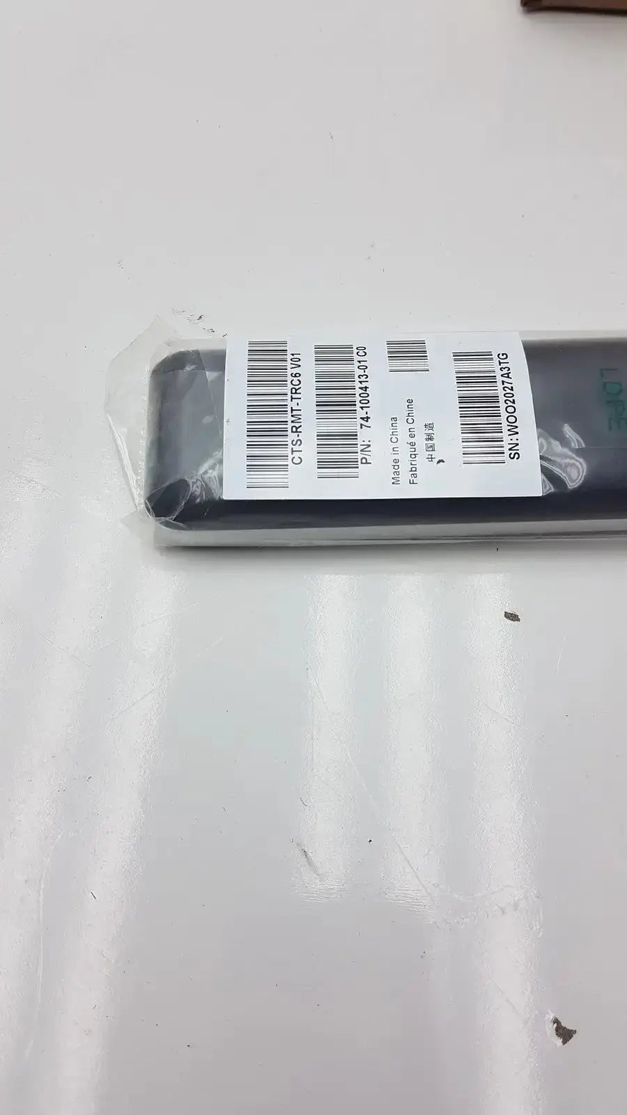 Black rectangular cisco cts-rmt-trc6 remote control wrapped in clear plastic with white barcode label for telepresence use