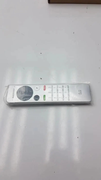 Silver cisco cts-rmt-trc6 remote control with a circular navigation pad and color-coded buttons for telepresence use