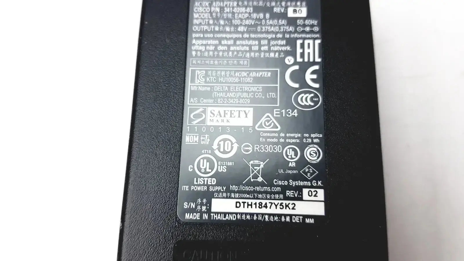 Black plastic cisco ip phone power supply cp-pwr-cube-3 with matte finish and printed safety certifications on back side