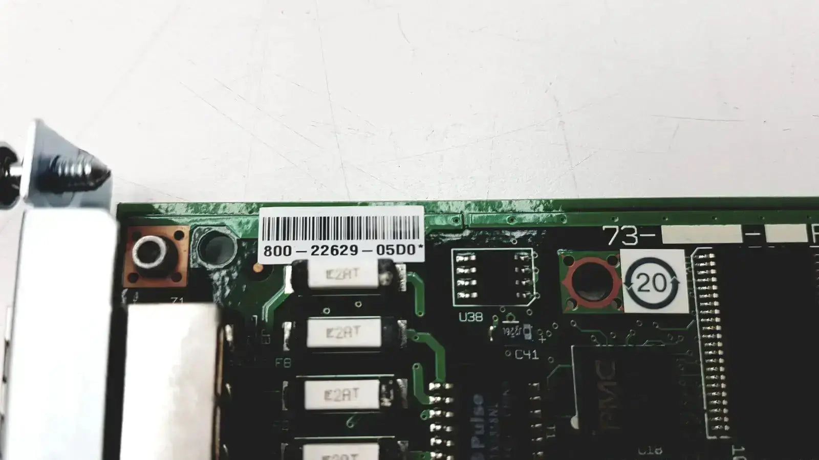 Green circuit board with black components and white barcode label of cisco vwic2 2mft-t1 e1 2-port voice wan module