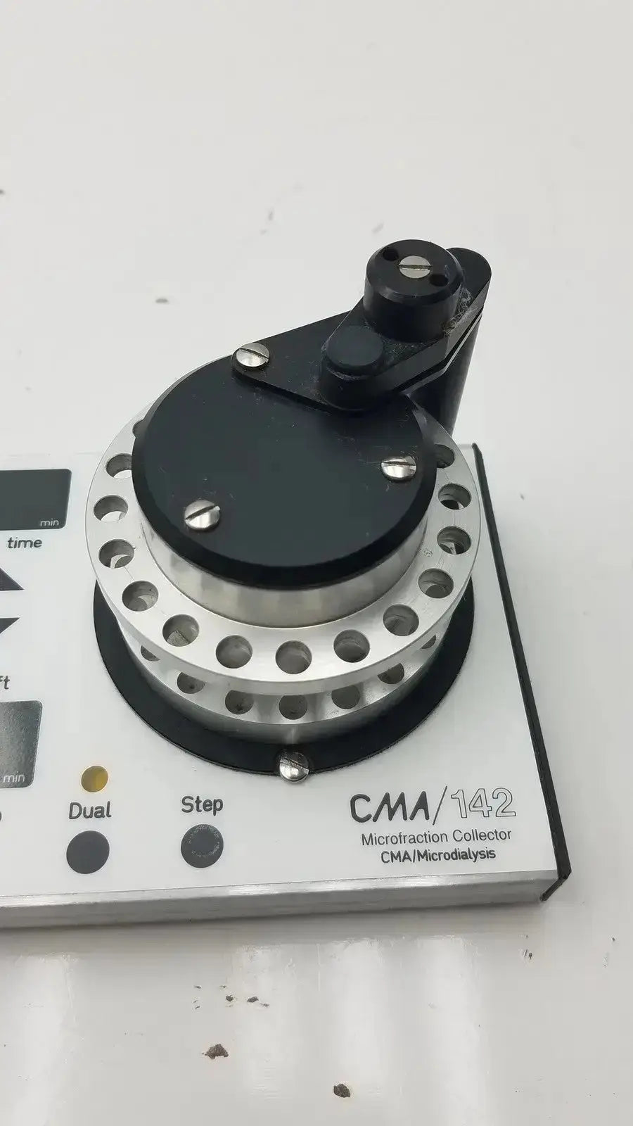 Black and silver cma microfraction collector model 142 with circular perforated metallic base and black top housing