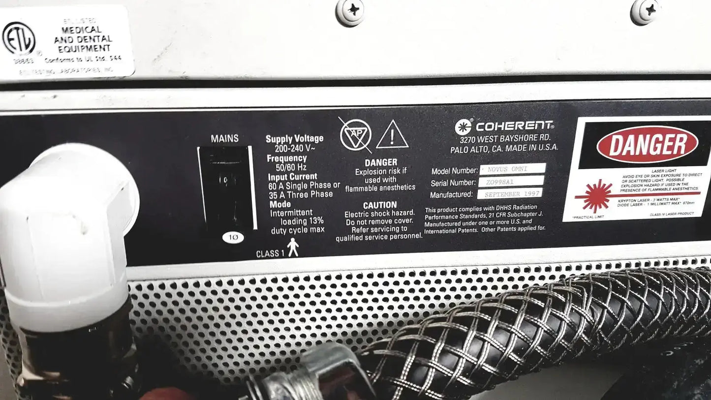 Coherent novus omni ophthalmic photocoagulation laser system panel with black label white text and warning symbols 220 volt