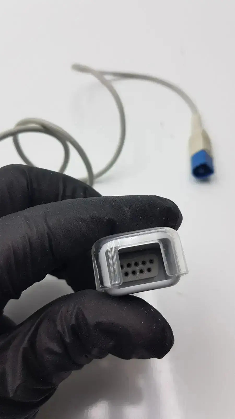 Gray medical spo2 extension cable connector with clear plastic housing and multiple holes for electrical contacts