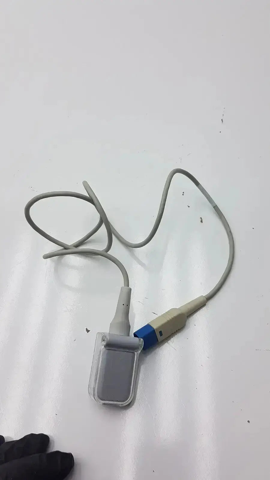 Gray medical pulse oximeter with clear plastic sensor housing and blue beige connector for spo2 extension cable use