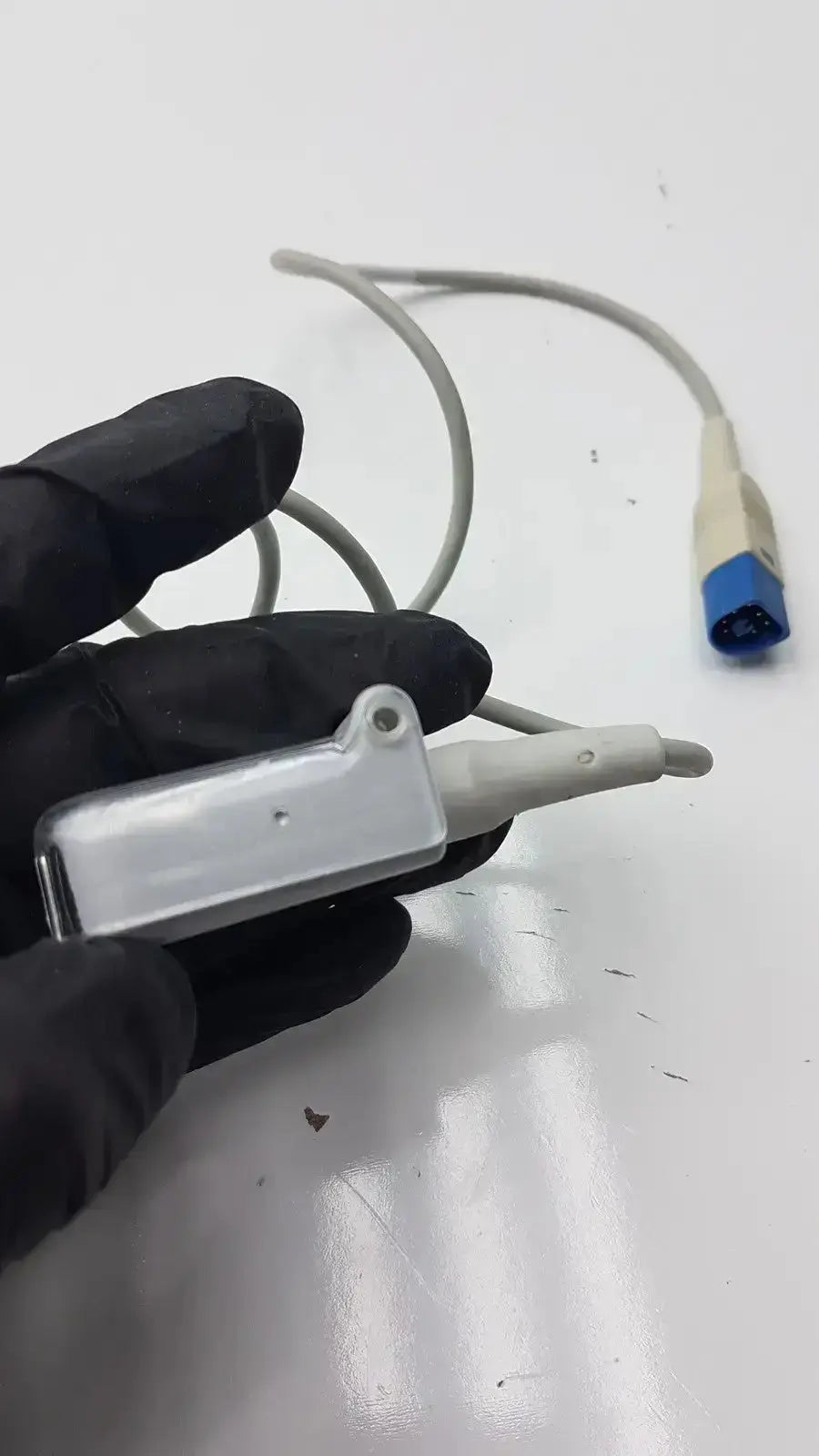 Gray plastic ultrasound transducer probe with clear cap and blue connector for compatible drager spo2 extension cable