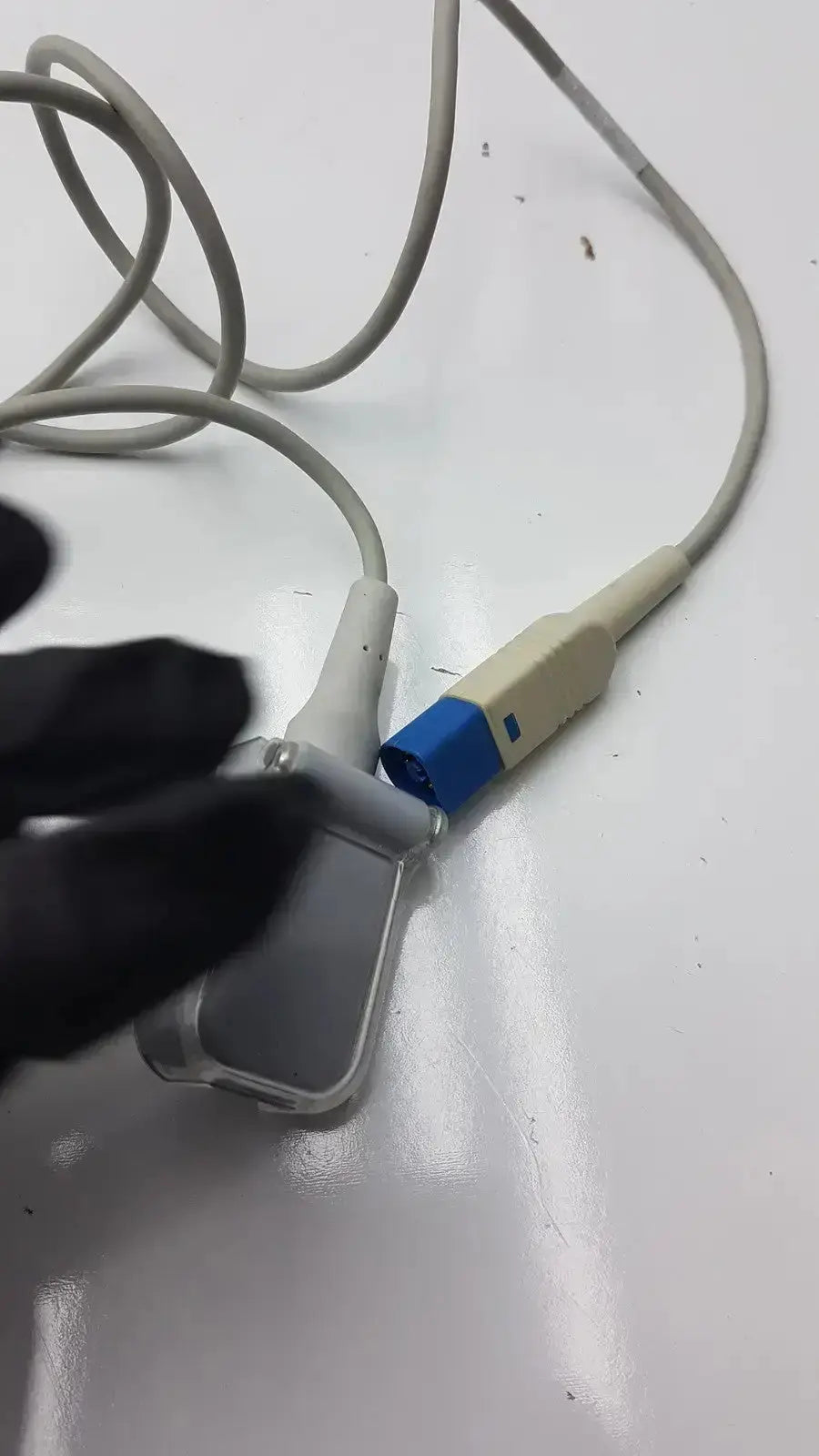 Gray medical ultrasound transducer with blue connector and beige housing for compatible Drager SpO2 extension cable use