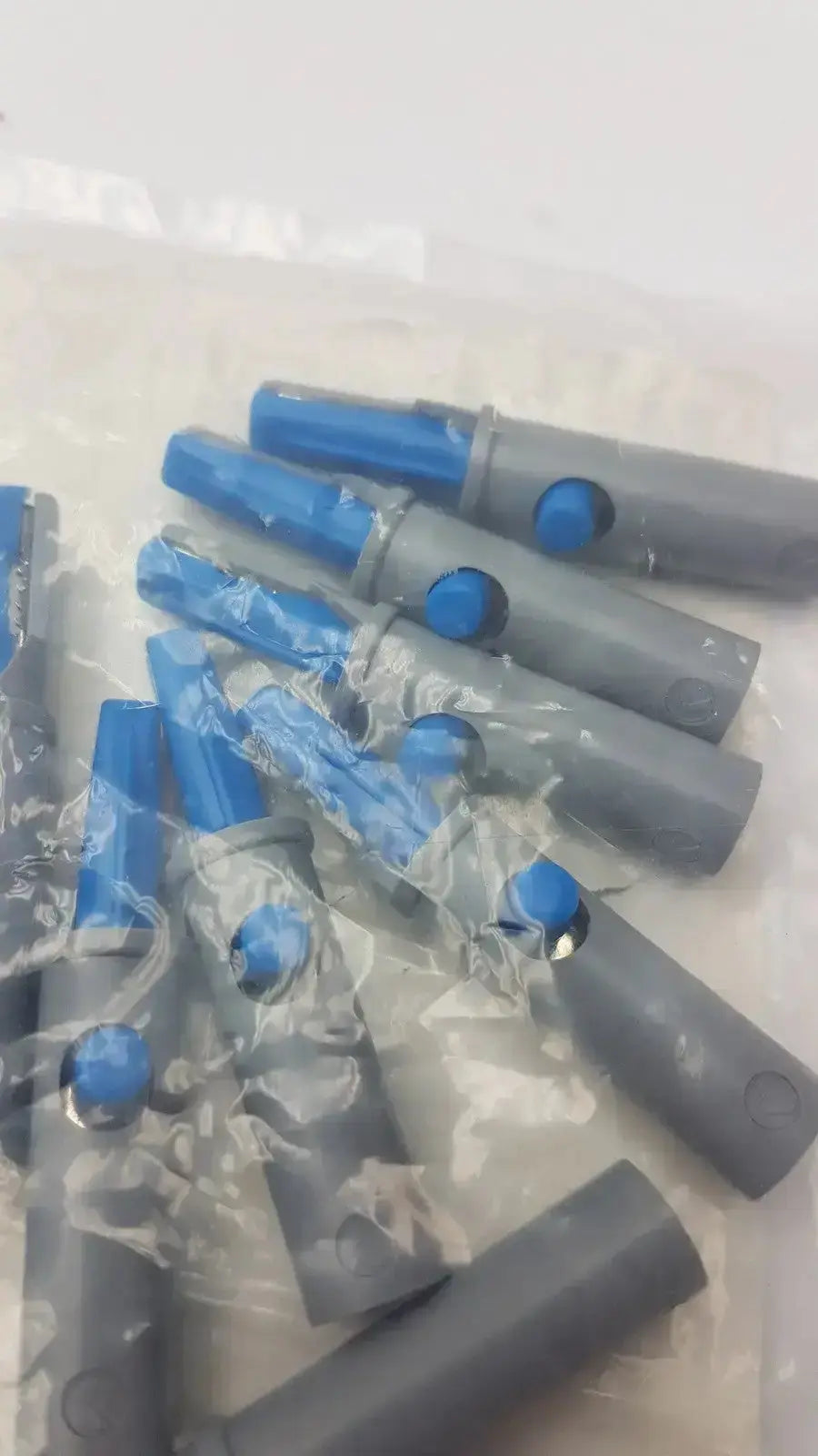 Conmed banana adapter 10 pk featuring gray and blue plastic connector pieces with circular buttons on each end