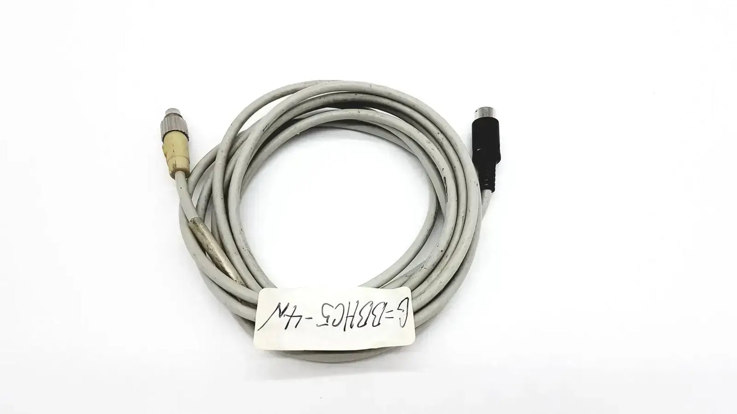 Gray control techniques connecting cable coiled with one metallic and one black connector for industrial use