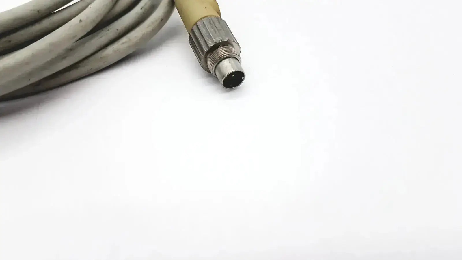 Gray coiled control techniques connecting cable with metallic threaded collar connector and black central port