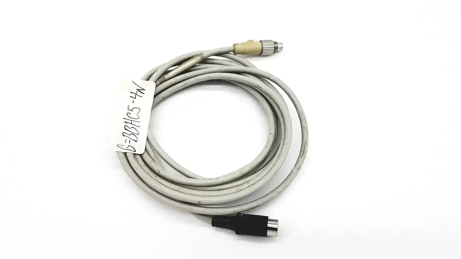 Gray coiled control techniques connecting cable with beige metallic and black plastic connectors for industrial use