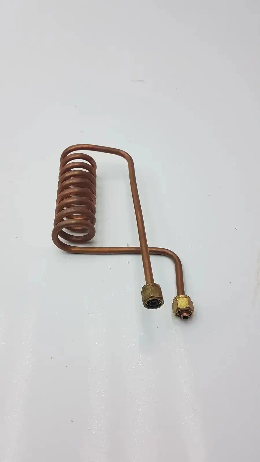 Copper nickel fin tube coil heat exchanger featuring a copper-colored coiled tube with brass fittings