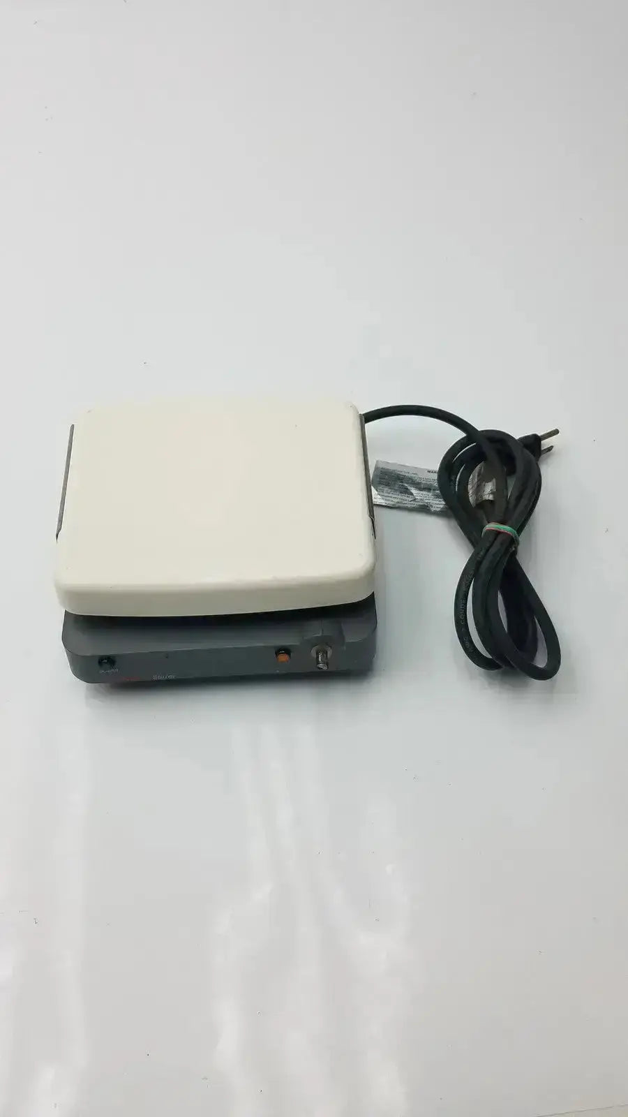 Cream-colored rectangular corning laboratory stirrer model RC-310 with black power cord and control panel for lab use