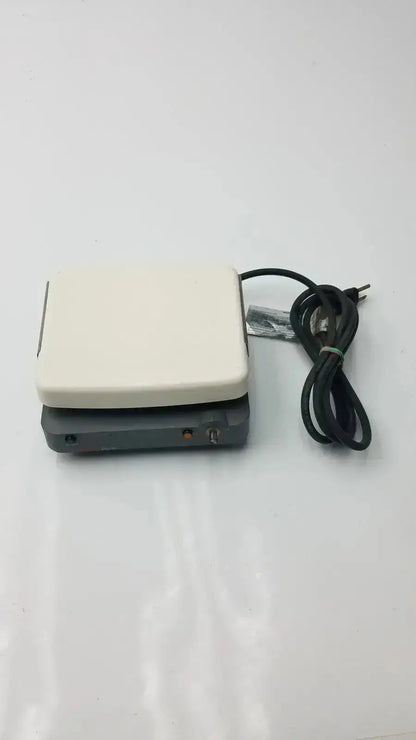 Cream-colored rectangular corning laboratory stirrer model RC-310 with black power cord and control panel for lab use