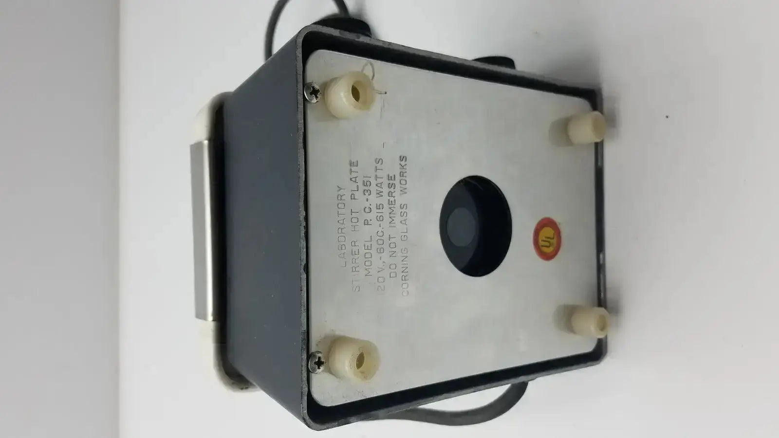 Corning PC-351 black and silver laboratory hot plate stirrer with circular opening, beige feet, and visible wiring