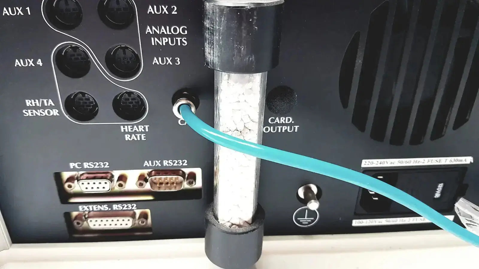Teal cable plugged into silver metallic port on the back of cosmed quark b2 pulmonary gas exchange device