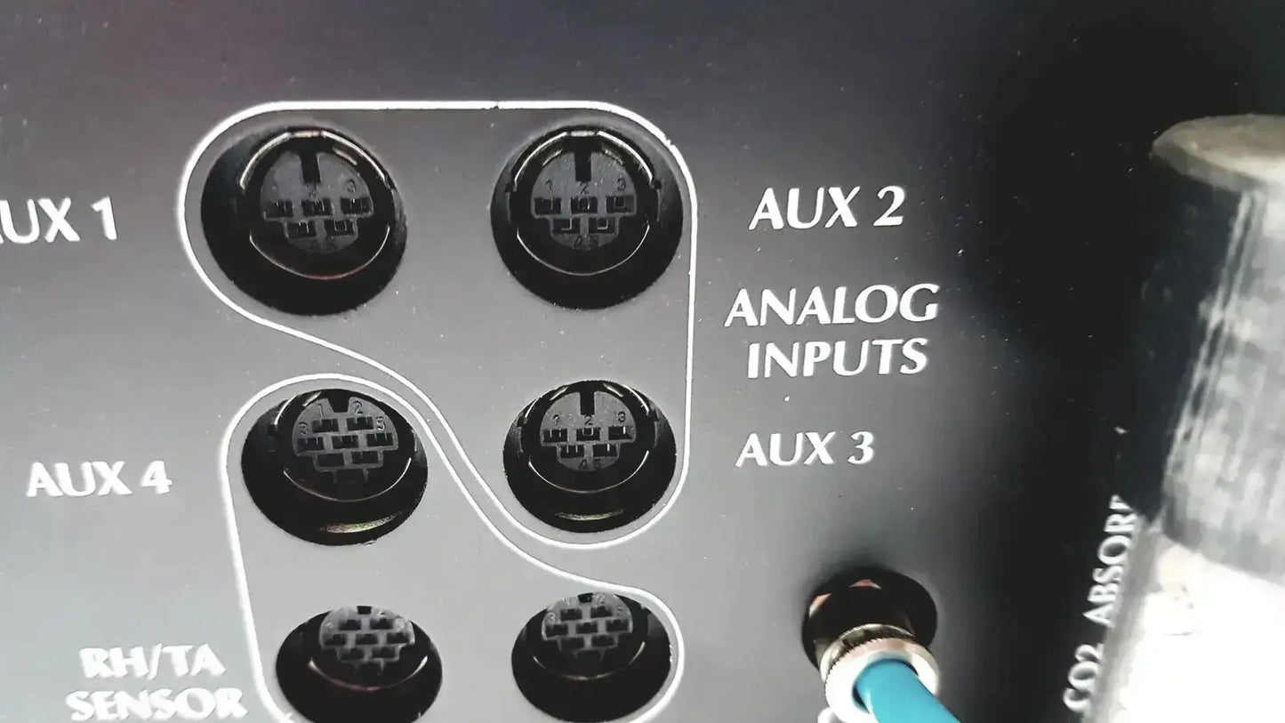 Back of black cosmed quark b2 pulmonary gas exchange device with six analog aux input jacks and blue cable plugged in