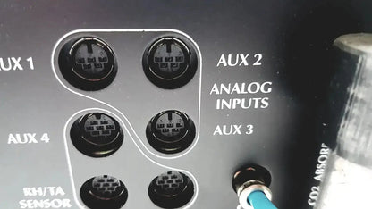 Back of black cosmed quark b2 pulmonary gas exchange device with six analog aux input jacks and blue cable plugged in
