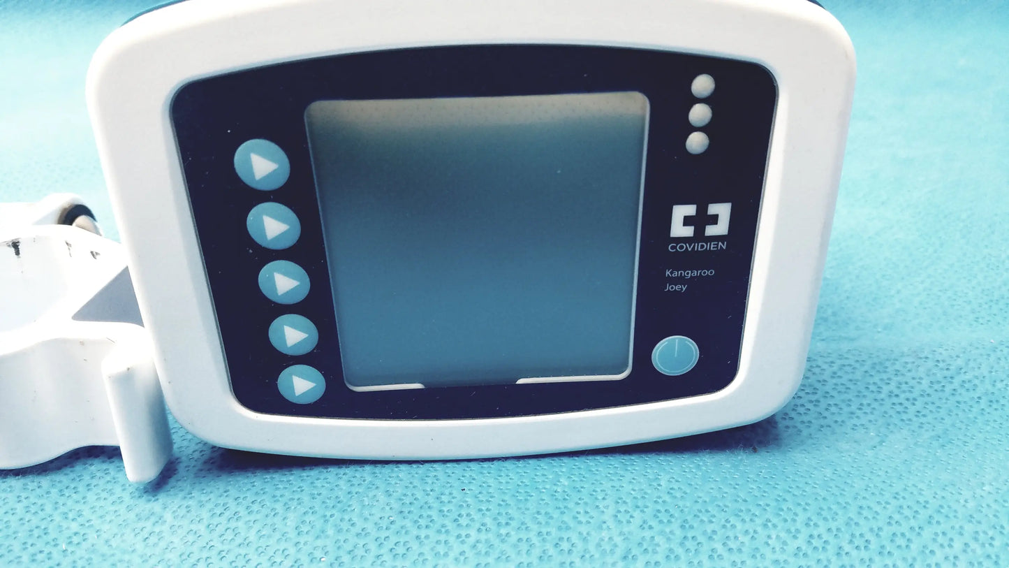 White plastic Covidien kangaroo joey enteral flush pump with black screen blue buttons and pole clamp attachment